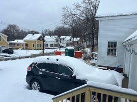 Snow in March covering car in an un-shoveled driveway
