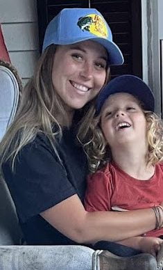 Jack sitting on Gracie's lap on porch chair, both smiling