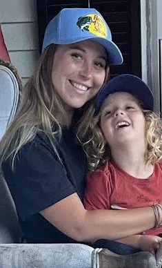 Jack sitting on Gracie's lap on porch chair, both smiling