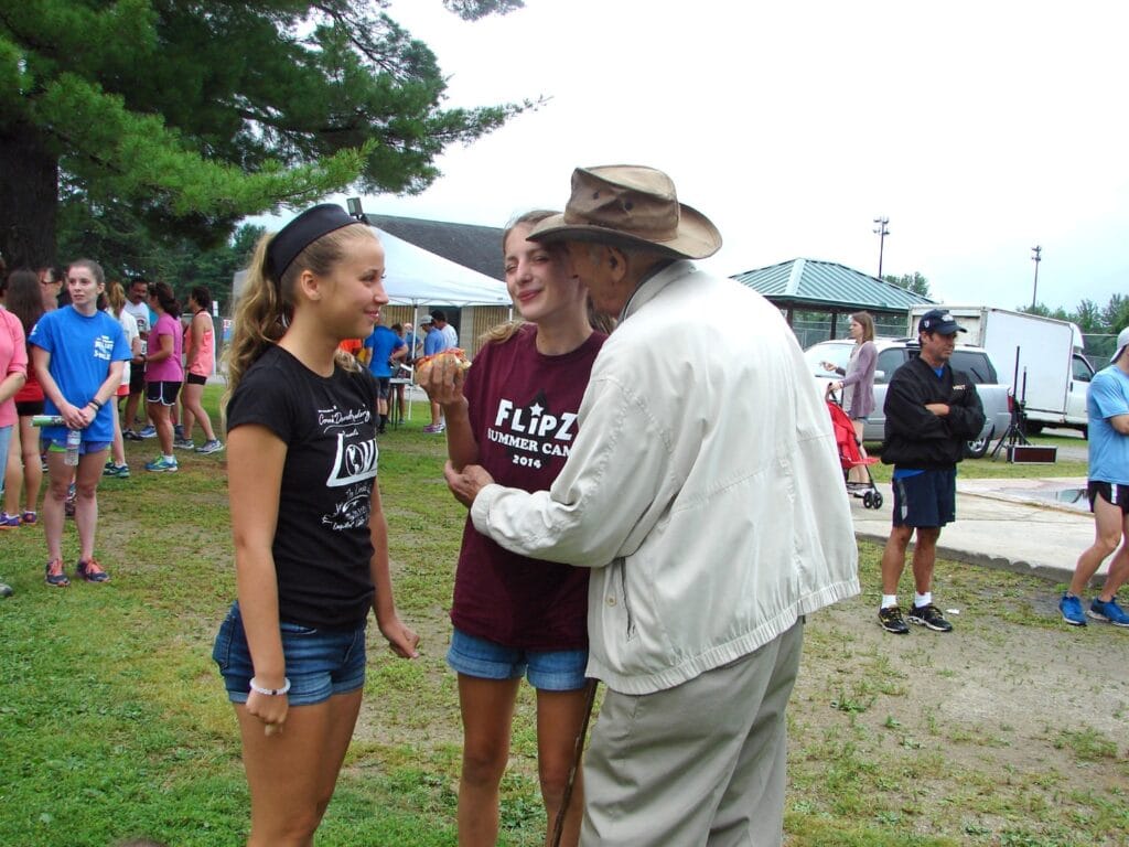 Molly and Coach Luti interacting outdoors at a camp event.