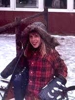 young barb after skiing, smiling at camera with winter jacket half on